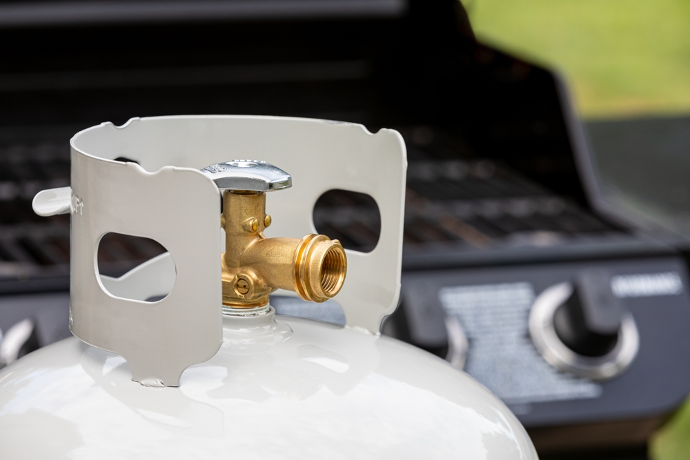 Propane tank up close in front of a grill